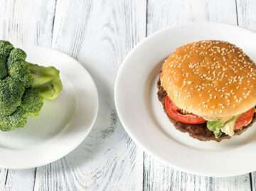 Hamburger and broccoli on separate plates representing food choices and mood