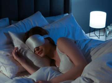 Woman relaxing with sleep mask for better sleep hygiene