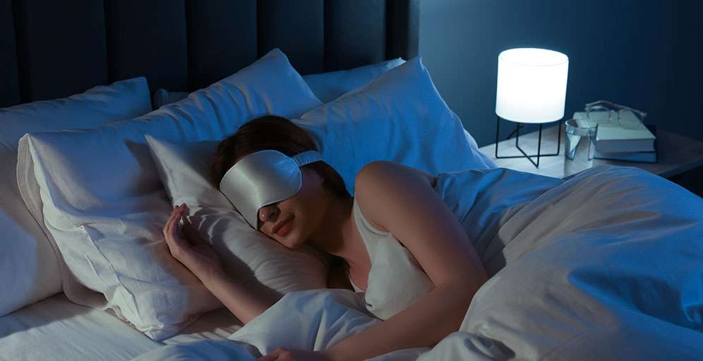 Woman relaxing with sleep mask for better sleep hygiene